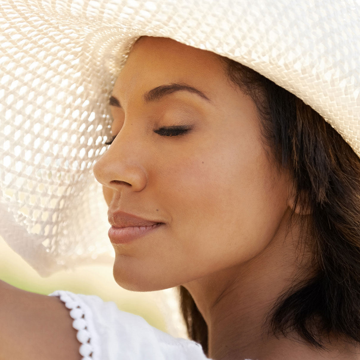 woman wearinga white hat with her eyes closed